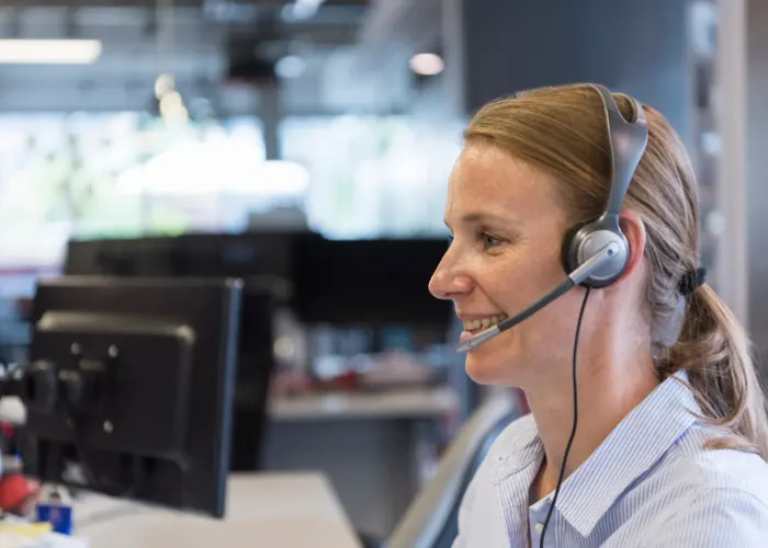 Customer service representative at Sell My House Fast in Casselberry wearing a blue shirt and a headset